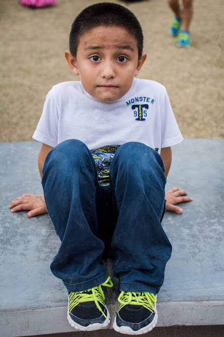 young boy sitting on the ground